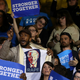 A protester wears a shirt with an image of former U.S. president Bill Clinton and the word ‘rape’ as democratic presidential nominee former Secretary of State Hillary Clinton speaks during a campaign rally at Wayne State University on October 10, 2016 in Detroit, Michigan. Photo via Getty